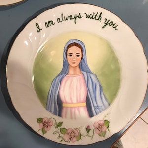 Retrato pintado a mano de la Virgen María en un plato de porcelana con borde plateado. &quot;Siempre estoy contigo&quot; pintado a mano en escritura cursiva.