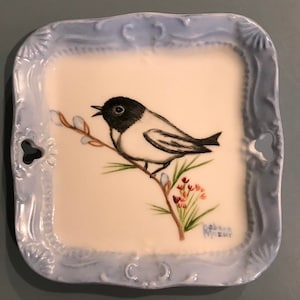 Little chickadee on a beautiful coaster plate
