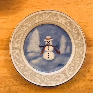 Handpainted plate with an adorable snowman on it with winter scenery all in blue