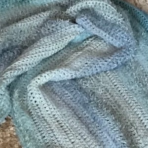 May include: A soft, blue and gray crocheted throw blanket with a fuzzy texture.