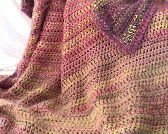 May include: A crocheted throw blanket in shades of pink, purple, and green. The blanket has a textured, striped pattern.