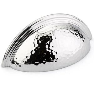 May include: A silver-toned, hammered, cup-shaped cabinet pull with a raised, decorative rim.