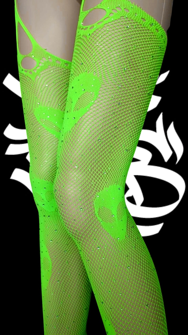 May include: Green fishnet stockings with rhinestones. The stockings have a large cut-out design on the thigh.