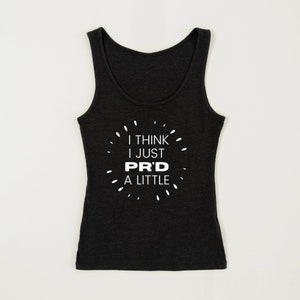 May include: Dark gray tank top with the text "I THINK I JUST PR'D A LITTLE" in white. The text is surrounded by small white dashes. The tank top has a scoop neck and is sleeveless.