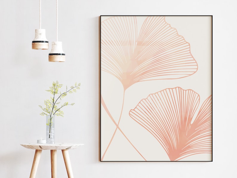 May include: A minimalist art print featuring two stylized ginkgo leaves in a soft peach color on a white background.