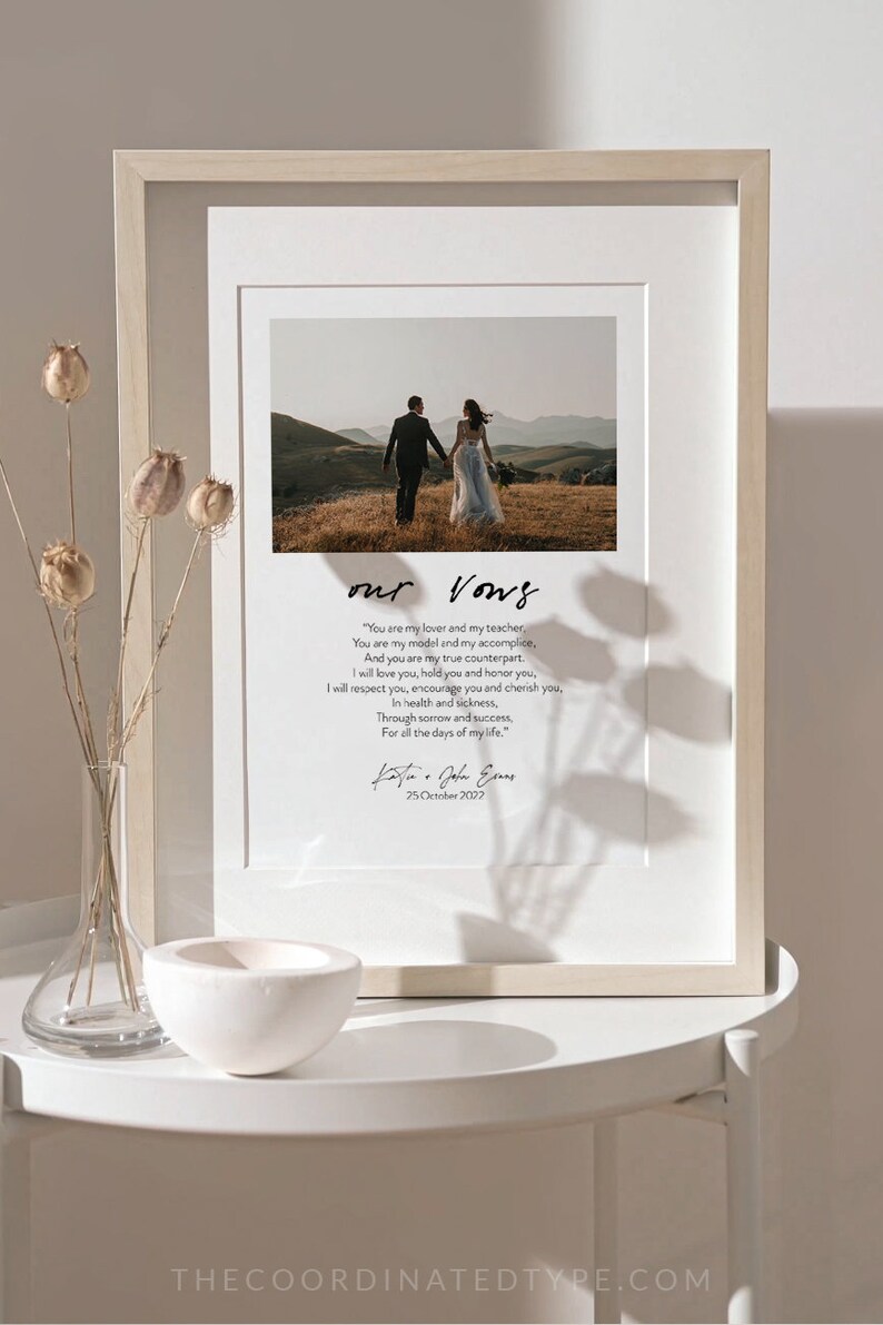Puede incluir: Una impresi&oacute;n enmarcada de votos de boda con una foto en blanco y negro de una pareja caminando hacia la c&aacute;mara. Los votos est&aacute;n escritos en una fuente cursiva y el texto dice "Eres mi amante y mi maestro, Eres mi modelo y mi c&oacute;mplice, Y eres mi verdadera contraparte. Te amar&eacute;, te tendr&eacute; y te honrar&eacute;, Te respetar&eacute;, te animar&eacute; y te apreciar&eacute;, En la salud y en la enfermedad, En la tristeza y en el &eacute;xito, Por todos los d&iacute;as de mi vida." La impresi&oacute;n est&aacute; firmada "Katie & John Evans" y la fecha "25 de octubre de 2022".