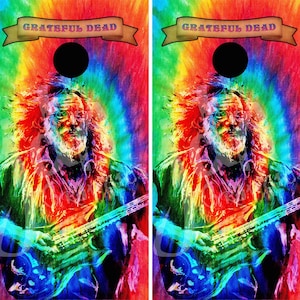 May include: Cornhole boards featuring a vibrant tie-dye background with a portrait of a musician playing a guitar. The boards have a black circle at the top and the words "Grateful Dead" on a banner.