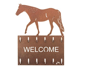 May include: A rusty brown metal horse silhouette with a key rack underneath. The rack has 10 hooks and says "WELCOME" in white lettering.