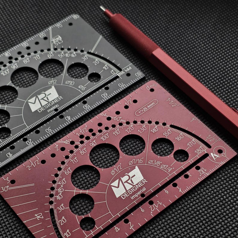 May include: Two metal drafting templates and a red mechanical pencil. One template is black with metric markings, and the other is maroon with imperial markings. Both feature circular cutouts, protractor scales, and the MRF Designer logo.