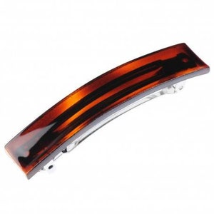 May include: A brown tortoiseshell hair clip with a silver metal bar. The clip is curved and has a smooth, glossy finish.