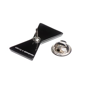 May include: Black bow tie pin with a silver pin back. The back of the pin says "Handmade in Europe".