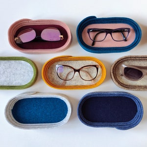 Puede incluir: Conjunto de diez portagafas de fieltro en varios colores, incluyendo azul, amarillo, verde y rosa. Cada portagafas tiene una forma circular con un interior suave y mullido diseñado para proteger las gafas.