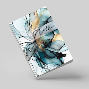 May include: A spiral bound notebook with a white cover featuring a blue and gold abstract floral design. The word "Notes" is written across the cover.