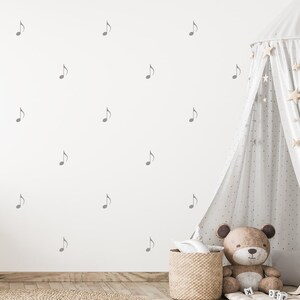 May include: A white wall with a gray musical note pattern. A white teepee tent with gold stars is in the corner of the room. A brown teddy bear sits in front of the teepee.