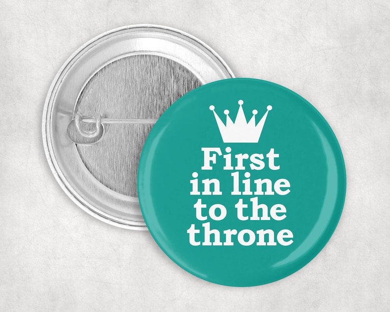 May include: A teal blue button with a white crown and the text "First in line to the throne".