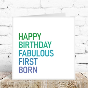 May include: A white card with the text "HAPPY BIRTHDAY FABULOUS FIRST BORN" in a gradient of green, blue, and purple.