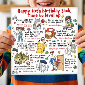 May include: A square, white birthday card with colourful illustrations and text. The card reads "Happy 10th birthday Jack, Time to level up." It features gaming-related trivia, including questions about cats, Pokemon, and Sonic the Hedgehog.