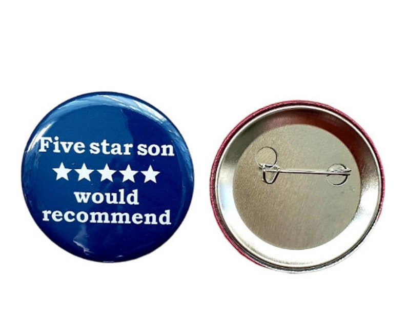 Op de afbeelding: Een blauwe knop met witte tekst die "Five star son would recommend" en vijf witte sterren zegt. De achterkant van de knop is zilver met een pin.