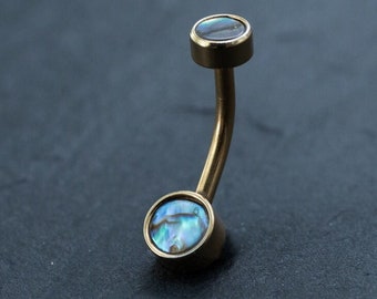 May include: A gold body jewelry barbell with iridescent blue and green abalone shell end caps.