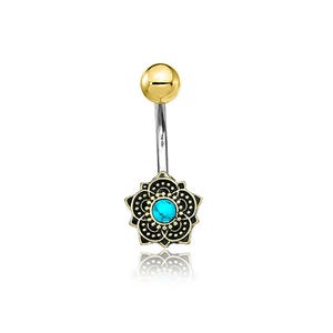 Puede incluir: Un piercing para el ombligo con una bola superior dorada y una barra curva plateada. El dije inferior es un diseño floral negro y dorado con una piedra central de color turquesa.