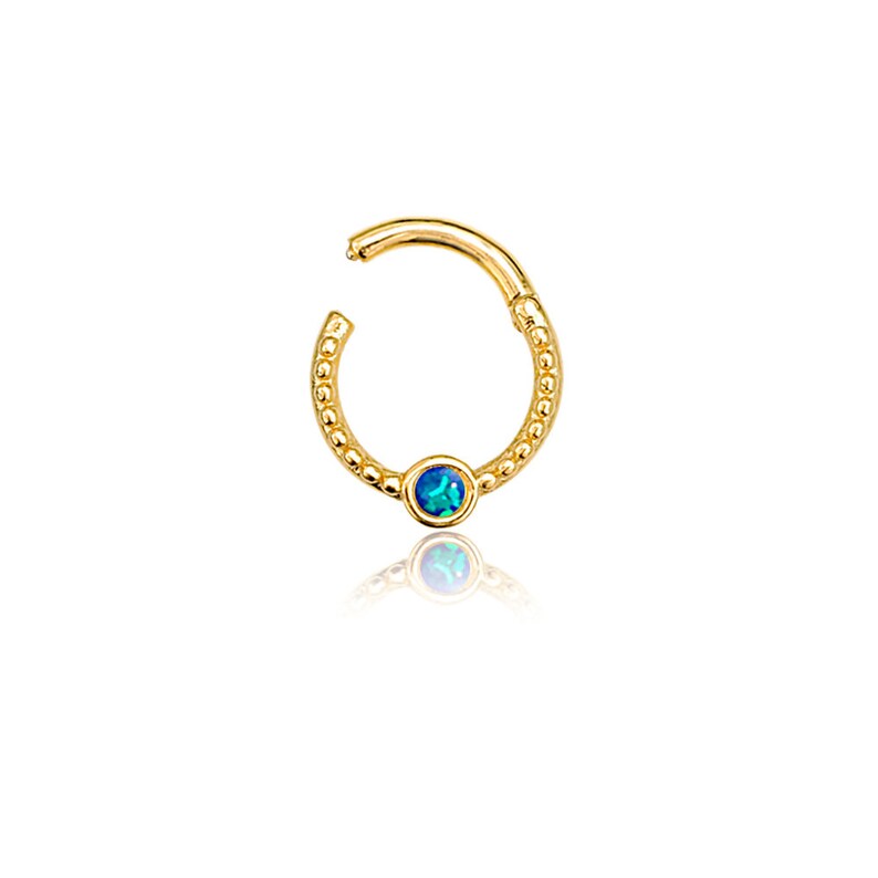 K&ouml;nnte beinhalten: Goldener Creolenohrring mit einem blauen Opal-Edelstein. Der Creolen ist perlenbesetzt und hat einen Scharnierverschluss.