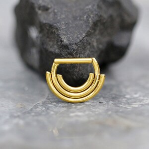 Pode incluir: Joia de piercing de anel segmentado triplo, tom dourado.