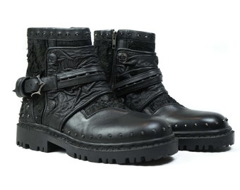 Pode incluir: Botas de tornozelo de couro preto com várias tiras e fivelas, detalhes com tachas e um design texturizado.