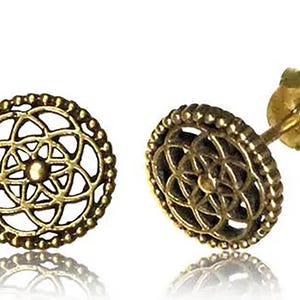 May include: A pair of gold-toned earrings with a circular design featuring a geometric pattern. The earrings have a post back closure.