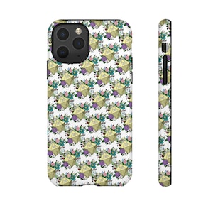 Puede incluir: Una funda de iPhone blanca con un patrón repetido de dados amarillos y flores moradas, azules y verdes.
