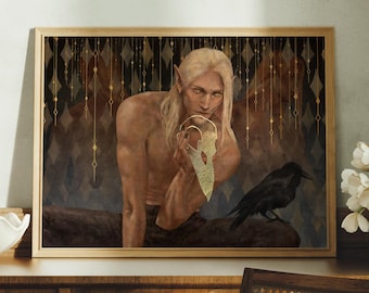 Op de afbeelding: Ingelijste kunstdruk met een mannelijke figuur met lang blond haar en puntige oren, die een gouden masker vasthoudt. Een zwarte raaf zit in de buurt. De achtergrond heeft een ruitpatroon met gouden accenten. Het kunstwerk wordt tentoongesteld op een houten oppervlak.