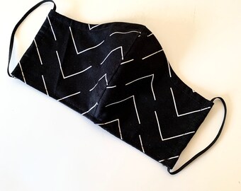 May include: Black face mask with white chevron pattern. The mask has elastic ear loops.