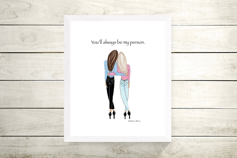 K&ouml;nnte beinhalten: Illustration von zwei Figuren, die sich umarmen, Jeans und Oberteile in Blau und Rosa tragen. Der Text "You'll always be my person" steht oben. Das Kunstwerk befindet sich in einem wei&szlig;en Rahmen.