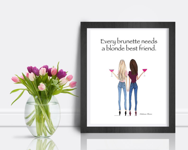 Puede incluir: Una impresi&oacute;n enmarcada con fondo blanco y marco negro. La impresi&oacute;n presenta una ilustraci&oacute;n dibujada a mano de dos mujeres, una con cabello rubio y otra con cabello casta&ntilde;o, sosteniendo c&oacute;cteles rosas. El texto "Every brunette needs a blonde best friend." est&aacute; impreso en negro en la parte superior de la impresi&oacute;n.