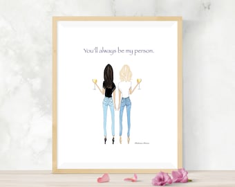 Puede incluir: Impresión enmarcada que muestra dos figuras, una con cabello oscuro y la otra rubia, sosteniendo copas de vino. Llevan vaqueros y camisetas. El texto "You'll always be my person" está encima.
