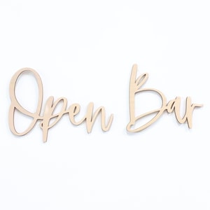 Peut inclure: Panneau "Open Bar" en bois avec une police cursive. Le panneau est en deux parties, avec "Open" sur une partie et "Bar" sur l'autre.