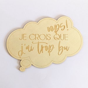 Peut inclure: Une pancarte en bois en forme de nuage avec le texte "oops! JE CROIS QUE j'ai trop bu" en police dorée.