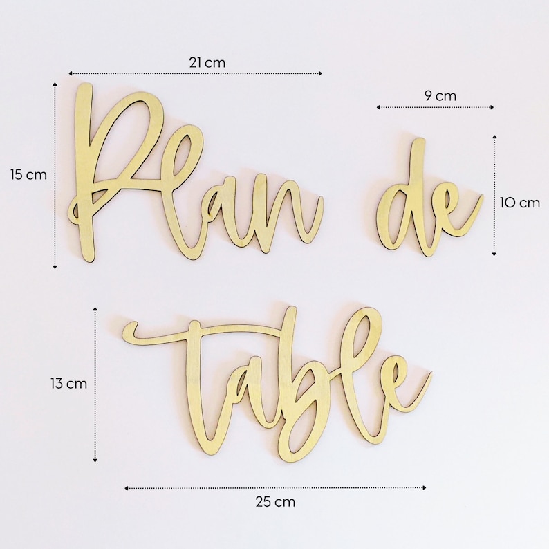 May include: Wooden sign with the words "Plan de Table" in a cursive font. The sign is 21 cm wide, 15 cm tall, and 13 cm high.