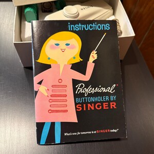 May include: A black and white instruction booklet for a Singer Professional Buttonholer. The booklet features a cartoon illustration of a woman in a pink dress holding a pointer stick. The text "What's new for tomorrow is at SINGER today!" is printed on the bottom of the booklet.