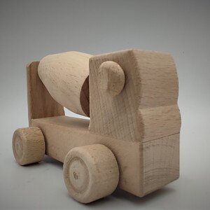 Peut inclure: Un camion toupie en bois jouet avec un tambour rotatif. Le camion a quatre roues et est fait de bois naturel.