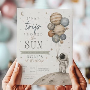 May include: A light beige birthday invitation with the text "First Trip Around the Sun." It features watercolor illustrations of planets, stars, and an astronaut holding planet balloons. The invitation includes event details and RSVP information.