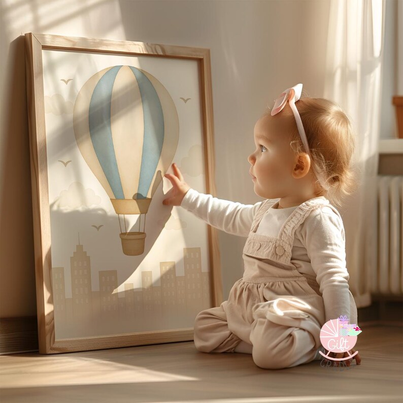 a little girl sitting on the floor in front of a picture of a hot air