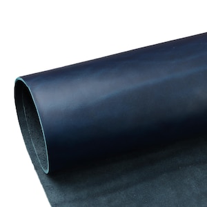 Puede incluir: Una hoja enrollada de cuero azul marino. El cuero tiene un acabado liso y brillante y un ligero brillo. Los bordes del cuero son visibles, revelando un interior azul más claro. El cuero parece ser de alta calidad y adecuado para varios proyectos de artesanía.