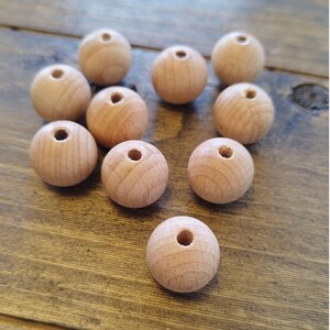 May include: Ten natural wood beads with a hole in the center. The beads are round and smooth, and they are all the same size.