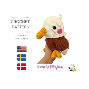 Może przedstawiać: Wzór na szydełku na pluszową zabawkę amigurumi w kształcie orła w kolorze brązowym i białym, o imieniu Rocky the eagle. Wzór dostępny jest w języku angielskim, szwedzkim i duńskim. Wzór można kupić na Etsy.