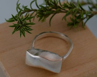 Anillo de plata de ley hecho a mano con diseño moderno de ondas geométricas.