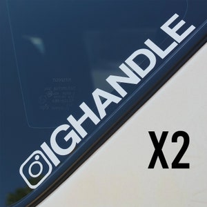 May include: White vinyl car window decal featuring the text "IGHANDLE" with an Instagram logo, and "X2" in black. The text is in a bold, sans-serif font. The decal is designed for application to a vehicle's window.