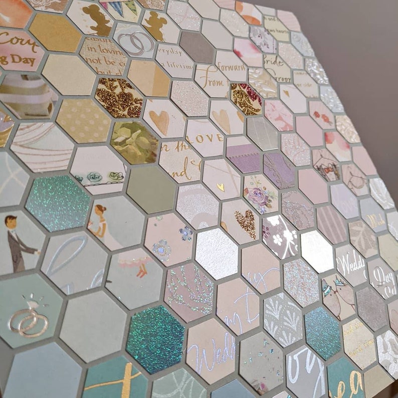 May include: A hexagonal wedding card with a light blue, green and pink colour scheme. The card is made up of many small squares with different patterns and designs. The text on the card includes "Wedding Day" and "For the Love".