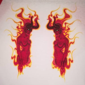 May include: A white t-shirt with red sleeves features a graphic of two red figures with horns and yellow flames. The figures are facing each other and are in a symmetrical design.