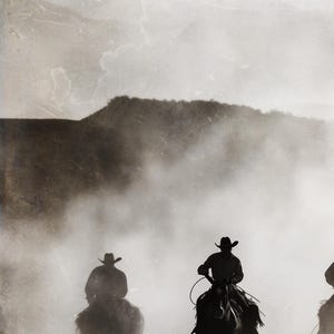 May include: Silhouettes of three cowboys riding horses through a dusty, foggy landscape. The cowboys are wearing hats and riding in a line, with the lead cowboy in the center of the image.