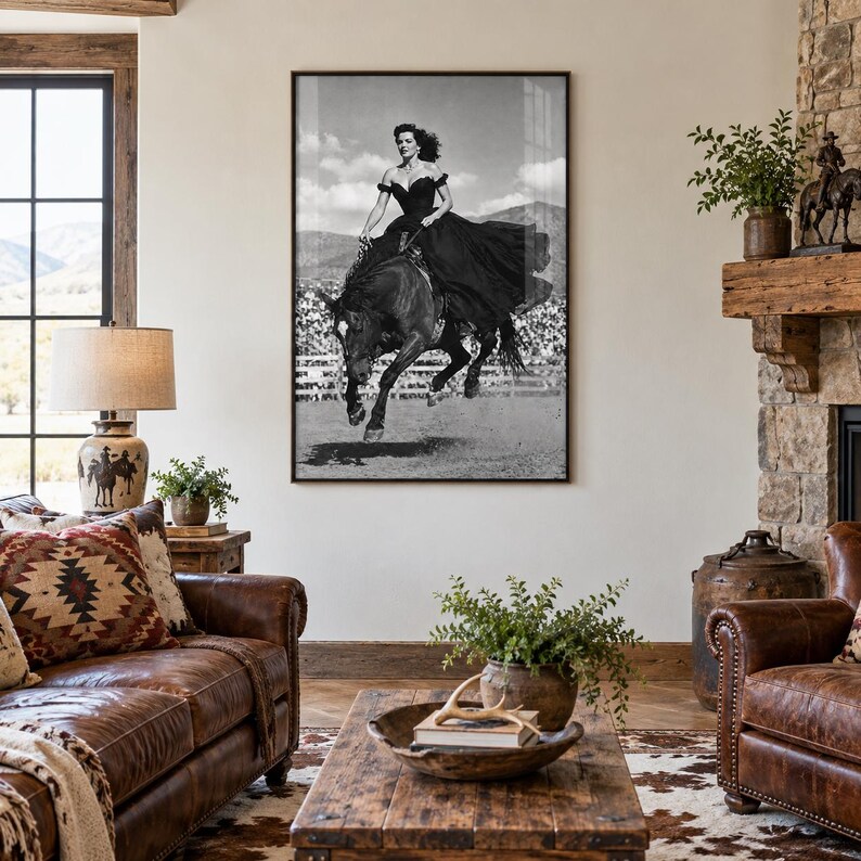 May include: A black and white framed wall art print depicting a person in a long dark gown riding a horse in a jumping motion. The image features a clear sky and a fence in the background, capturing a dynamic moment of equestrian movement.